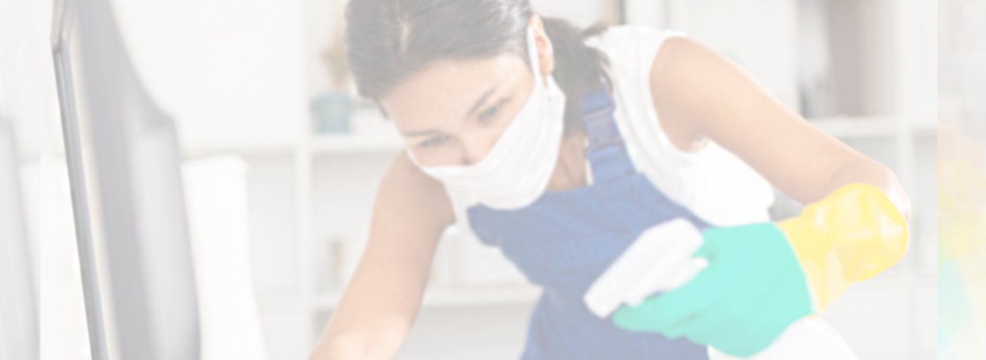 Close up of female cleaner in mask disinfecting high-touch surface area.